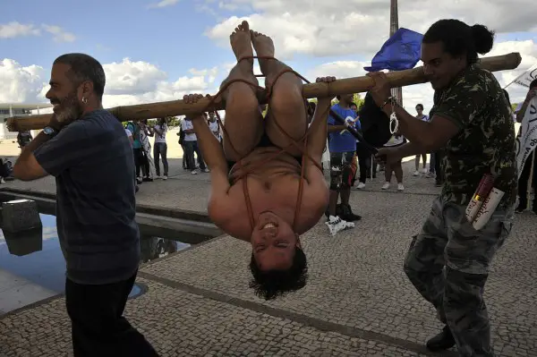 Legenda: Durante ato público em Brasília, em 2012, manifestantes simulam o pau de arara.
