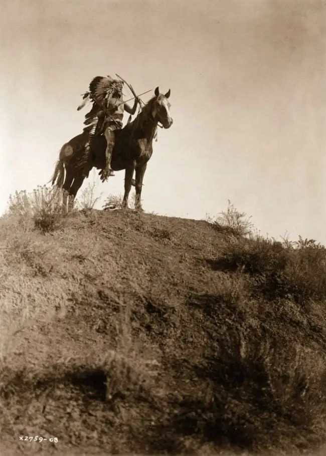 Um homem da tribo do corvo pronto para a batalha. Fotografia de 1908.